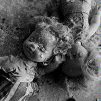 Black and white photo of two dolls covered with plaster.