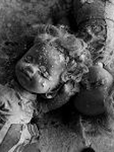 Black and white photo of two dolls covered with plaster.