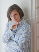 Photo of the Orchestra conductor - a woman holding a baton in her hand