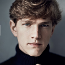 Photo of the artist - a face of a young man, who is looking straight into the camera