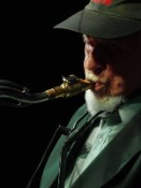 Dark photo of the musician: a man playing the saxophone