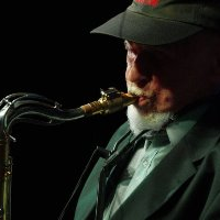 Dark photo of the musician: a man playing the saxophone