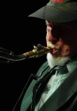 Dark photo of the musician: a man playing the saxophone