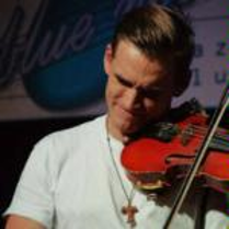 A man in a white T-shirt playing the violin