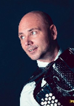 Photo of Marcin Wyrostek looking right and holding an accordion