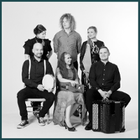 The black and white photograph shows the six members of the Okra team in two rows. In the first one, a woman and two men are sitting on chairs. Behind them are two more ladies and one gentleman. Some of them hold musical instruments.