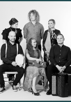 The black and white photograph shows the six members of the Okra team in two rows. In the first one, a woman and two men are sitting on chairs. Behind them are two more ladies and one gentleman. Some of them hold musical instruments.