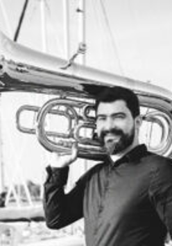 Black and white photograph of the artist - a man holding a tuba on his shoulder