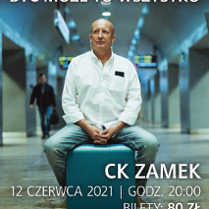 Photo of the artist in a white shirt and headphones, who is sitting on a turquoise pouf in a public space, probably in the underground passage of a train station or subway