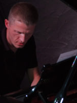 Photo in dark colours - a man playing the piano