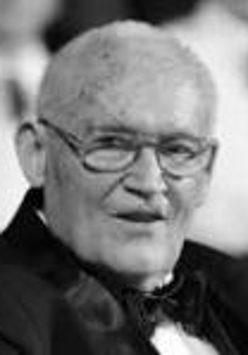 Black and white picture of Stefan Stuligrosz - an elderly man in glasses looking at the camera