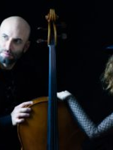A man and a woman with a cello between them
