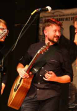 Three men playing guitars on a stage