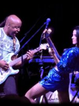 Photo of the artists: a man and a woman playing their guitars