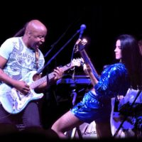 Photo of the artists: a man and a woman playing their guitars