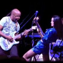 Photo of the artists: a man and a woman playing their guitars