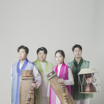 Photo of the band - three men and one woman stnding in their folk clothes with their musical instruments.