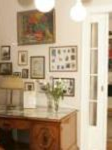 Photo of one of the rooms in Willa wśród Róż: antique desk and chair, pictures on the wall, open door to another room