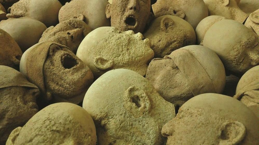 Photo of stone heads with open-mouthed faces