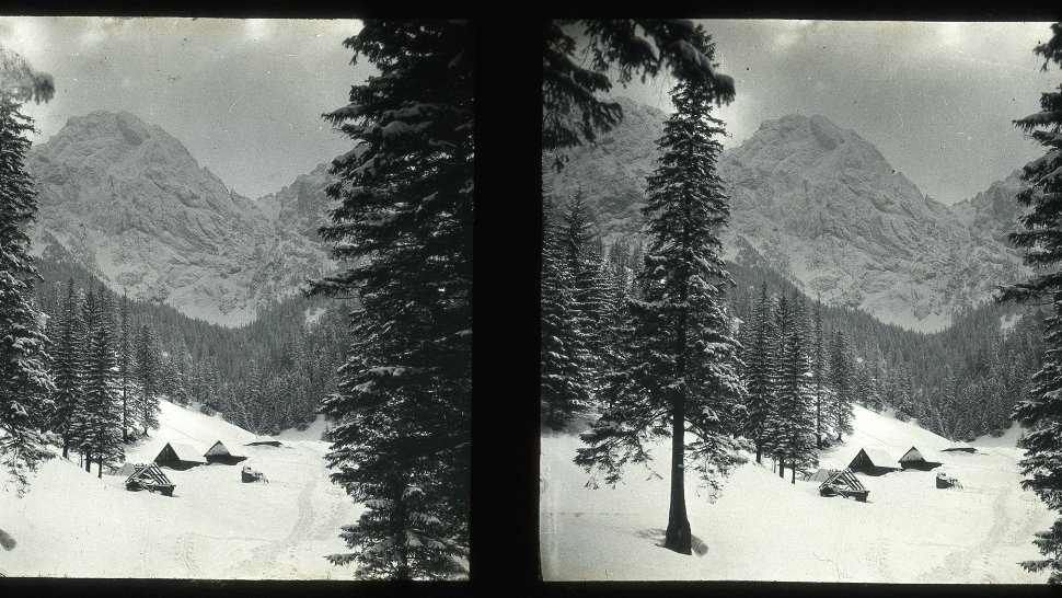 Double black and white photo of snow-covered mountains and trees. Three snow-covered houses in the background