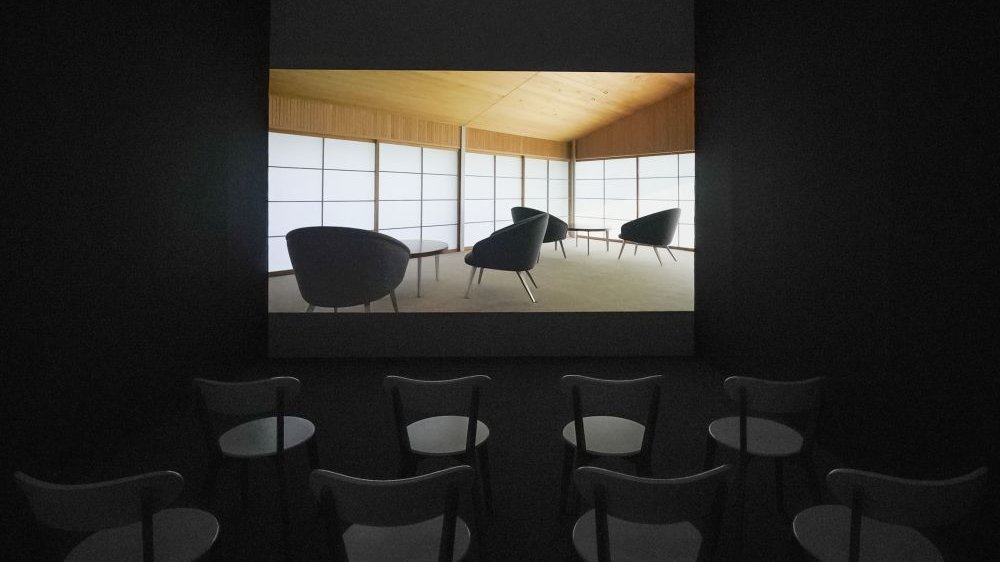 Picture of chairs standing in front of the photo with black chairs and white, Japanese-like walls.
