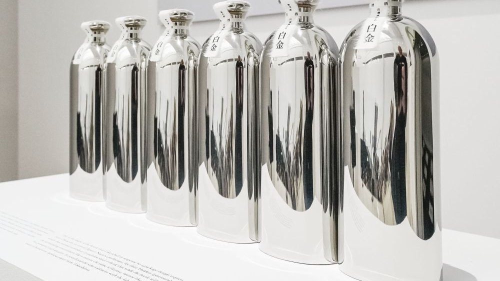 Photo of six silver bottles standing in a row.