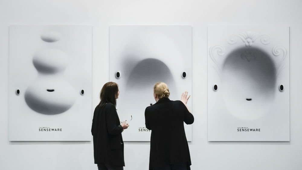 Picture of two women watching pictures on the wall.