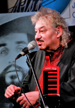 Photo of the artist - Piotr Kuźniak performing on stage.