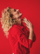 Photo of the singer dressed in red clothes on a red background