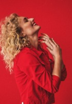 Photo of the singer dressed in red clothes on a red background
