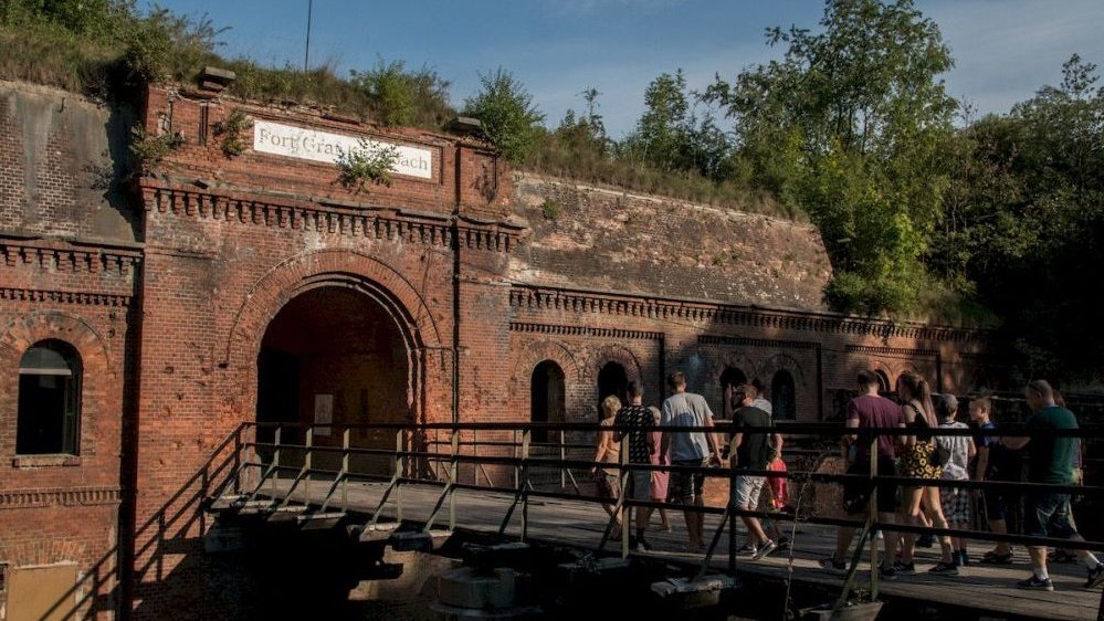 Photo of the entrance to the fort, some people going toward it along a footbridge.
