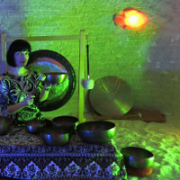 Photo of a woman playing gongs.