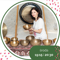 Photo of a woman holding a golden bowl. In front of her a few similar bowls.