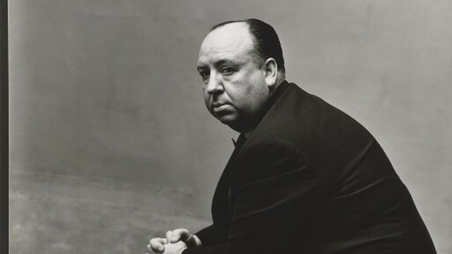 Black and white photo of Alfred Hitchcock, who is sitting.