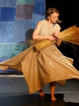 Photo from the performance: a woman with a bundle of flax.