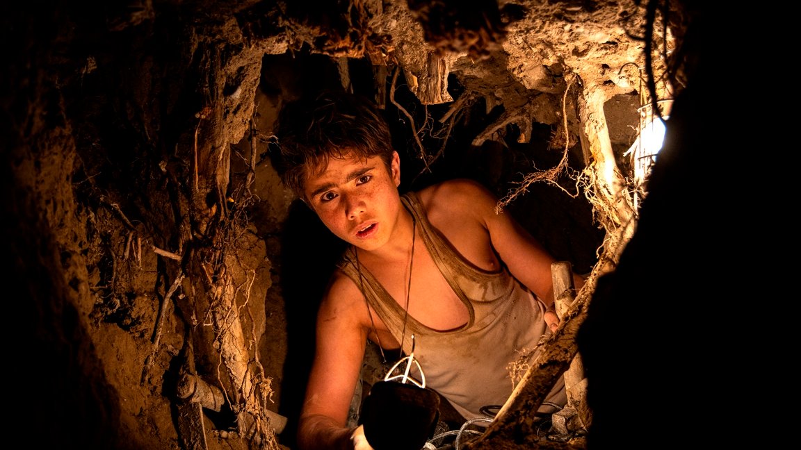 Picture from the movie - a boy in a place resembling an underground cave