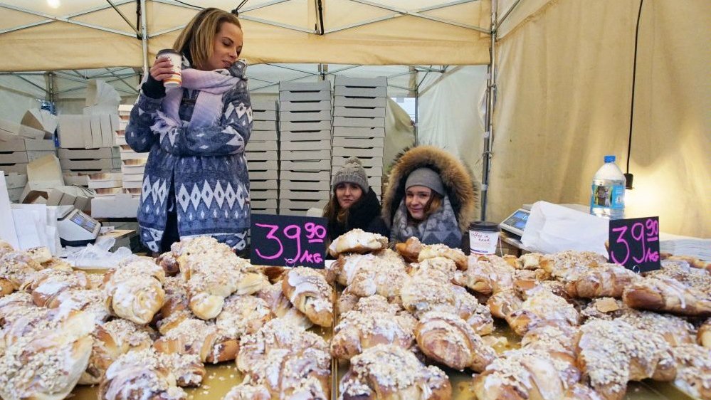 Photo from one of the previous St. Martin parade: a stand with traditional Poznań croissants, baked on November 11 and women selling them.