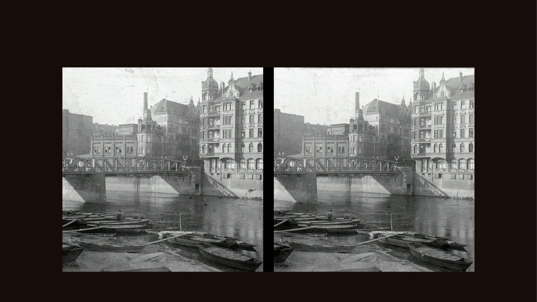 Black and white stereophotograph of the river, a few boats, the bridge and buildings along the river.
