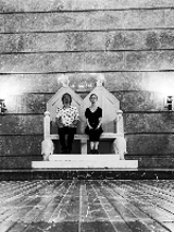 Black and white picture of two musicians sitting on the imperial throne in ZAMEK Culture Centre