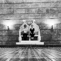 Black and white picture of two musicians sitting on the imperial throne in ZAMEK Culture Centre