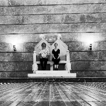 Black and white picture of two musicians sitting on the imperial throne in ZAMEK Culture Centre