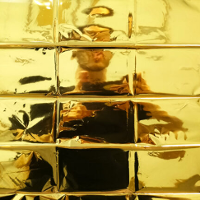 Photo of a person standing behind yellow, glass wall.