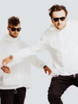 Photo of two men in white hoodies, black trousers and black sun-glasses with their arms outspread on white background