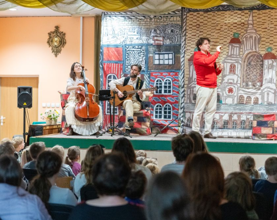 Aktorzy i muzycy występują na scenie.