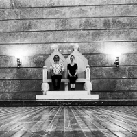 Kobieta i mężczyzna siedzący na podwójnym tronie.