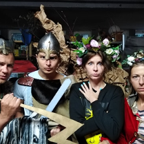 Dwóch mężczyzn i dwie kobiety w przebraniach teatralych. Mężczyźni mają stroje wojowników, a kobiety wieńce i peleryny.