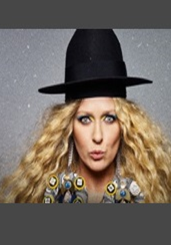 Zdjęcia na któym na tle przypominającym rozgwieżdżone niebo znajduje się Katarzyna Nosowska w czarnym kapeluszu.