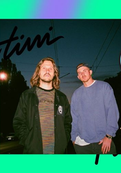 Zdjęcie mężczyzn na tle nocnego nieba w mieście. Widać przewody trakcji tramwajowej i światła samochodów.