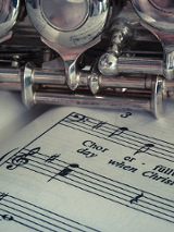 Flet leżący na zeszycie z nutami.