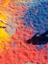 Dzieci chodzące po kolorowym, barwionym kruszywie.